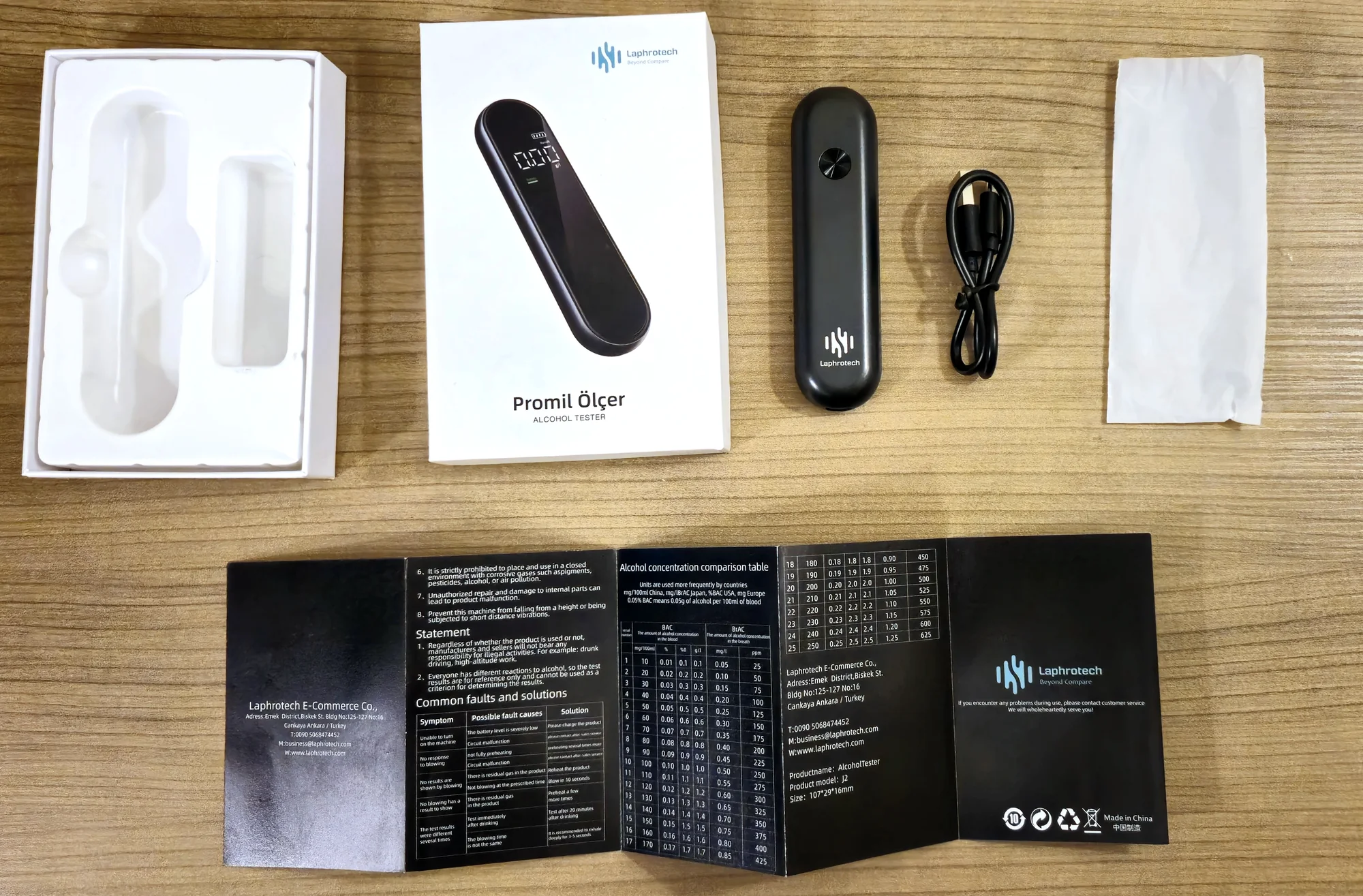 Açılmış J2 kutusu: cihaz, USB şarj kablosu, toz koruma kılıfı ve kullanım kılavuzu